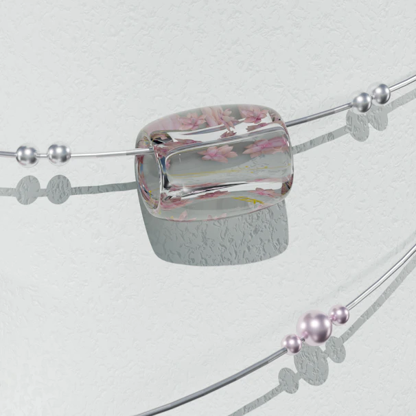 Elegant bracelet featuring intertwined zodiac signs against a backdrop of muted pastel stones and dried flowers