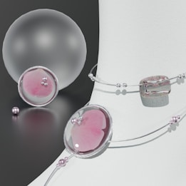 A composition of elegant jewelry pieces featuring pastel pinks and silver tones. Delicate strings of pearls and beads are artfully arranged around smooth, translucent orbs and geometric shapes, reflecting light on a neutral background.