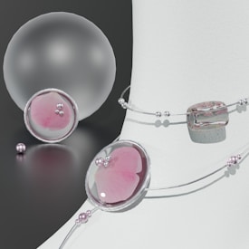 A composition of elegant jewelry pieces featuring pastel pinks and silver tones. Delicate strings of pearls and beads are artfully arranged around smooth, translucent orbs and geometric shapes, reflecting light on a neutral background.