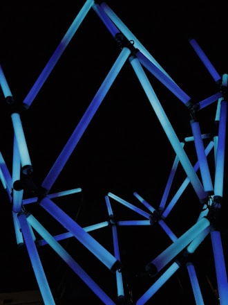 Abstract network of interconnected nodes glowing in electric blue on a dark charcoal background.