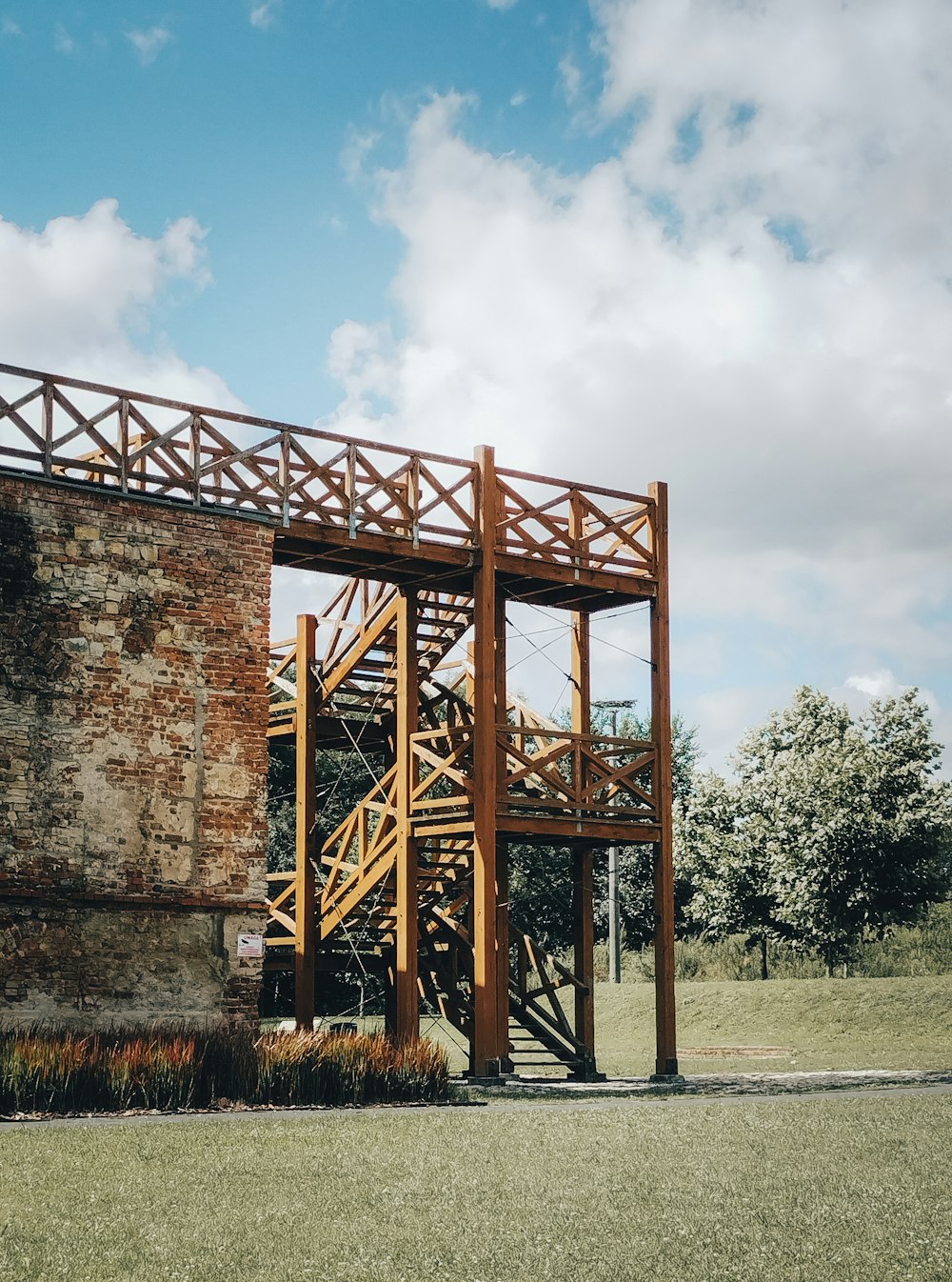 una alta estructura de madera sentada en la cima de un exuberante campo verde