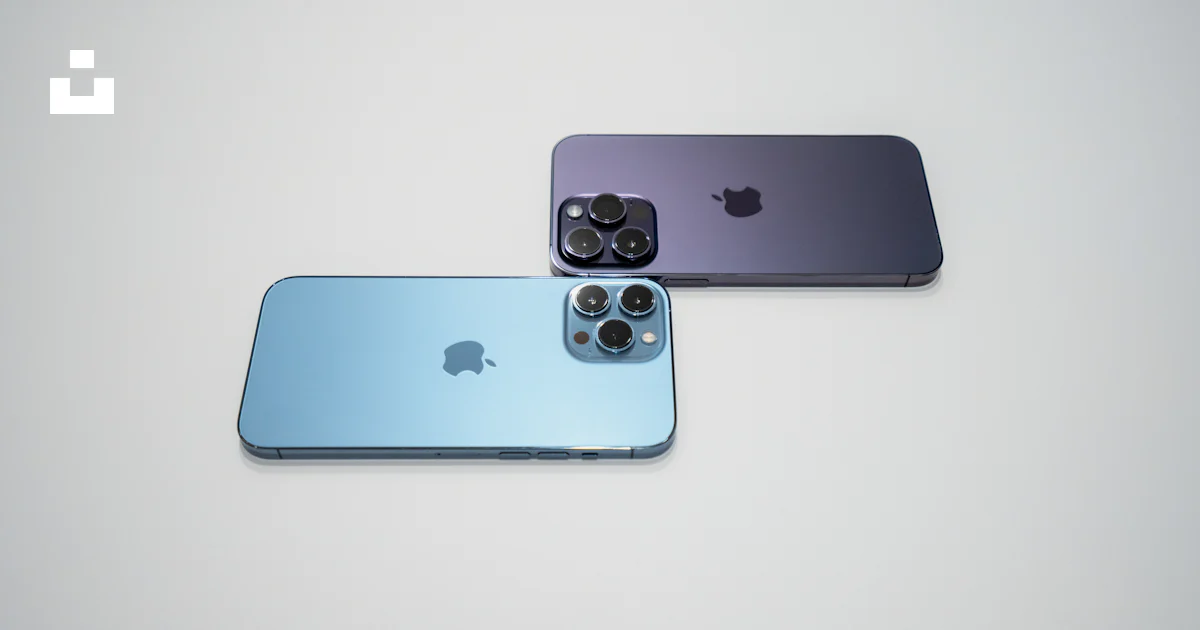 Two iphones side by side on a white surface photo – Free Iphone Image ...