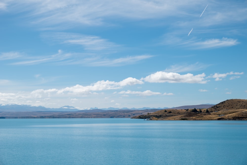 a large body of water with mountains in the background