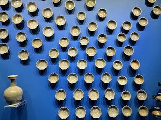 Brightly glazed ceramic bowls stacked neatly beside fresh flowers.