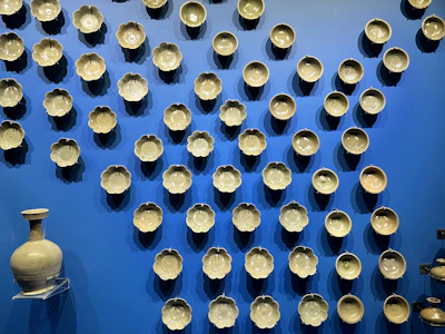 Brightly glazed ceramic bowls stacked neatly beside fresh flowers.