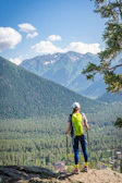 Brightly colored alpine backpacks packed and ready against a backdrop of pine trees.