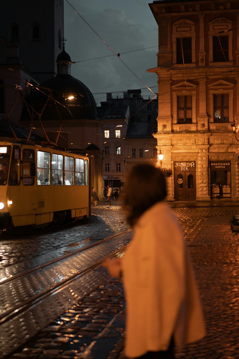 a person walking on a cobblestone street at night