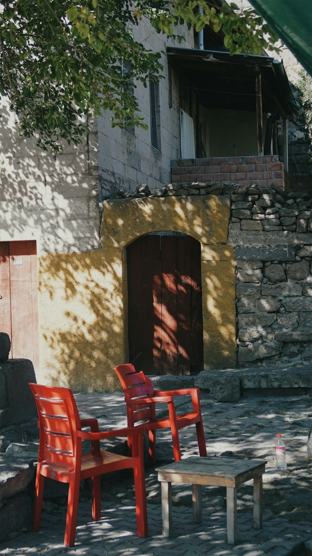 a couple of red chairs sitting next to a wooden table