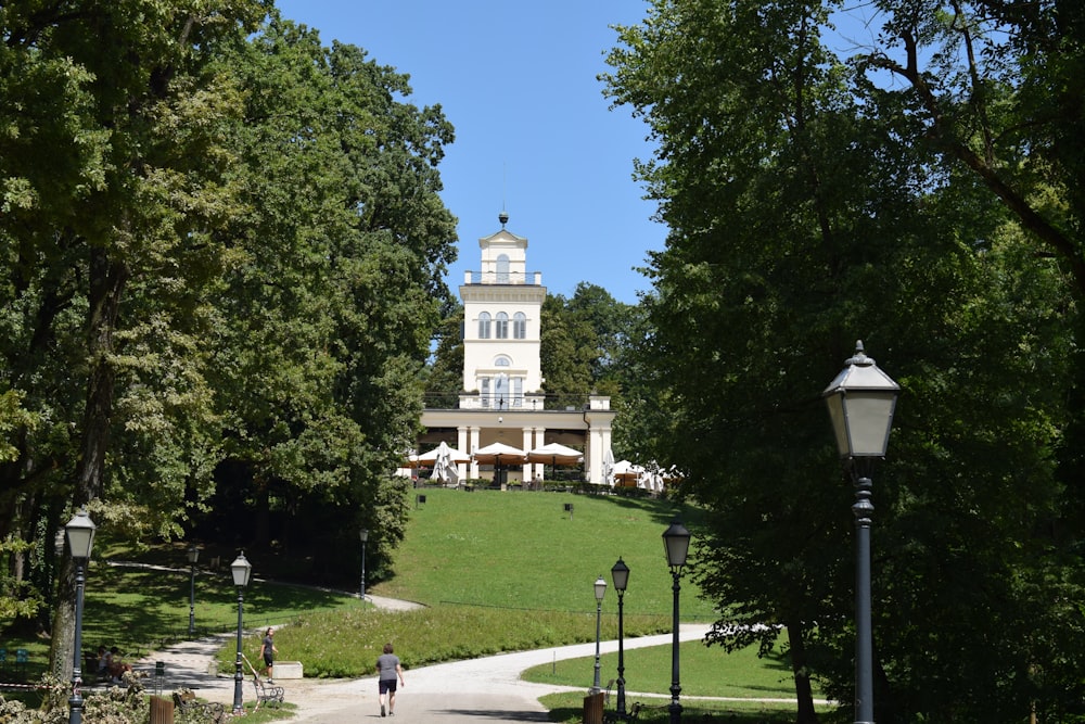 a large white building sitting on top of a lush green hillside