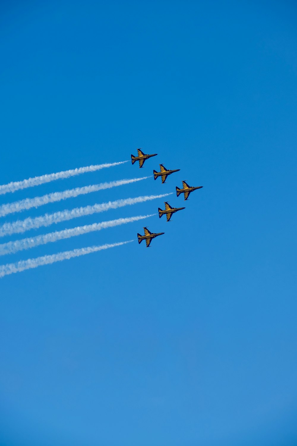 a group of fighter jets flying through a blue sky