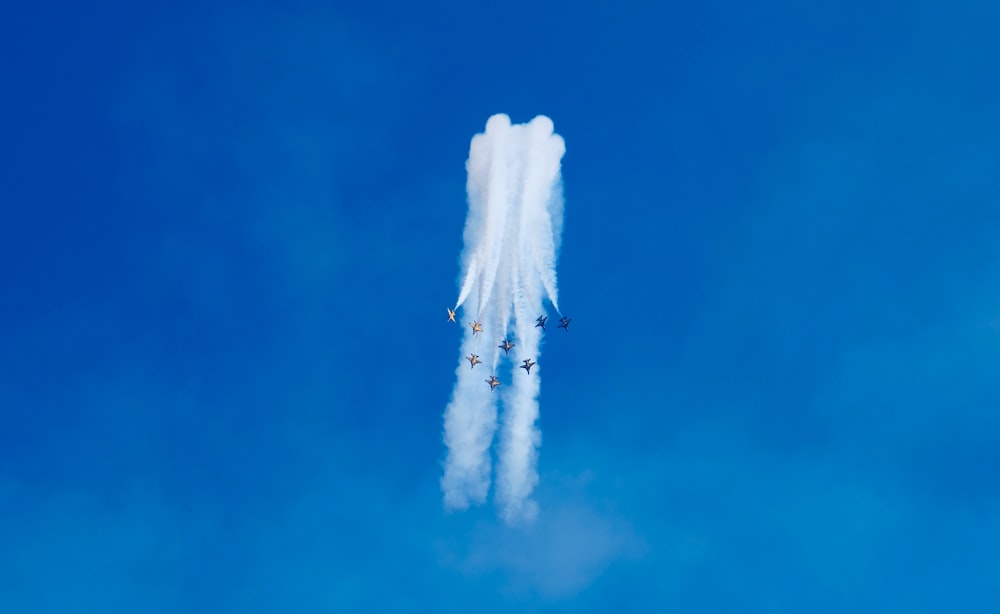 a group of airplanes flying through a blue sky