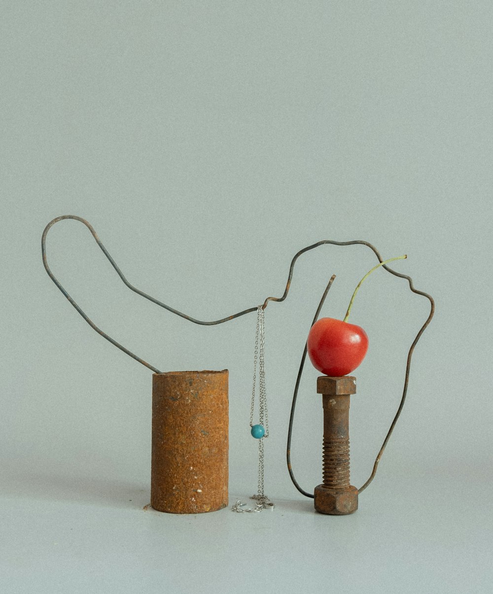 a sculpture made of a cork and a cherry on a string