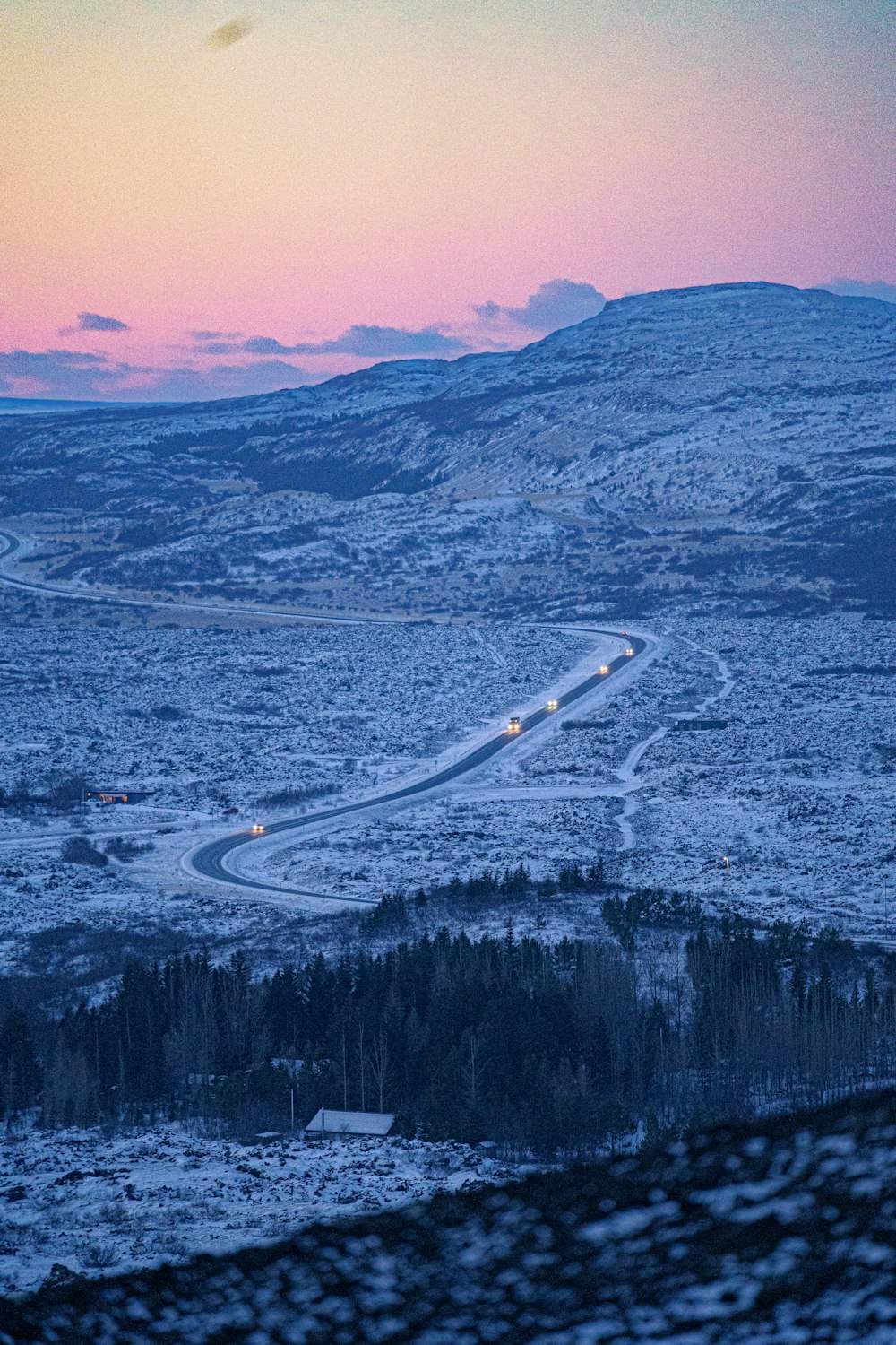 a winding road in the middle of a snowy landscape