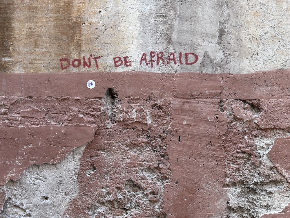 graffiti on a wall that says don't be afraid