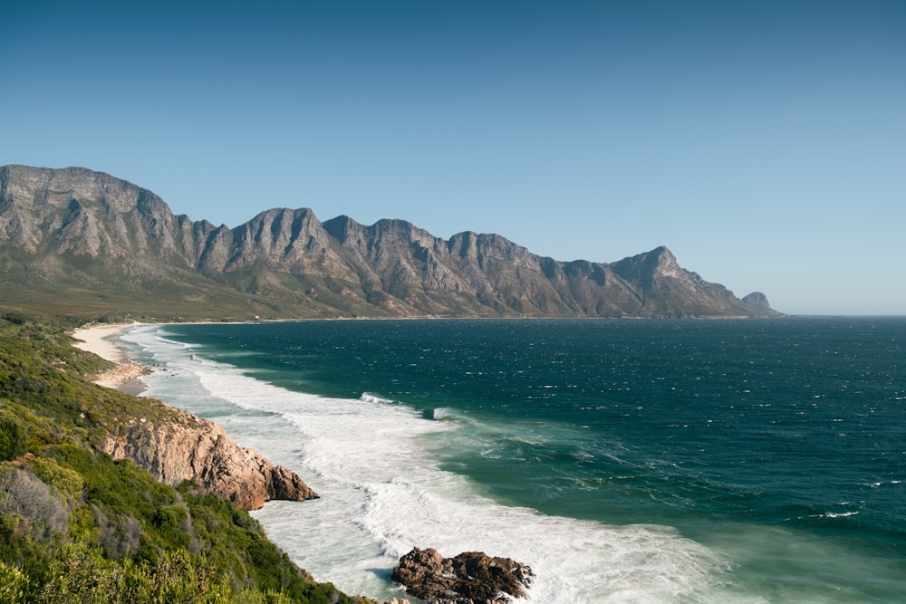 a large body of water with mountains in the background