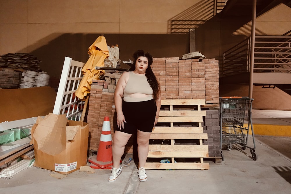 a woman standing next to a pile of wood