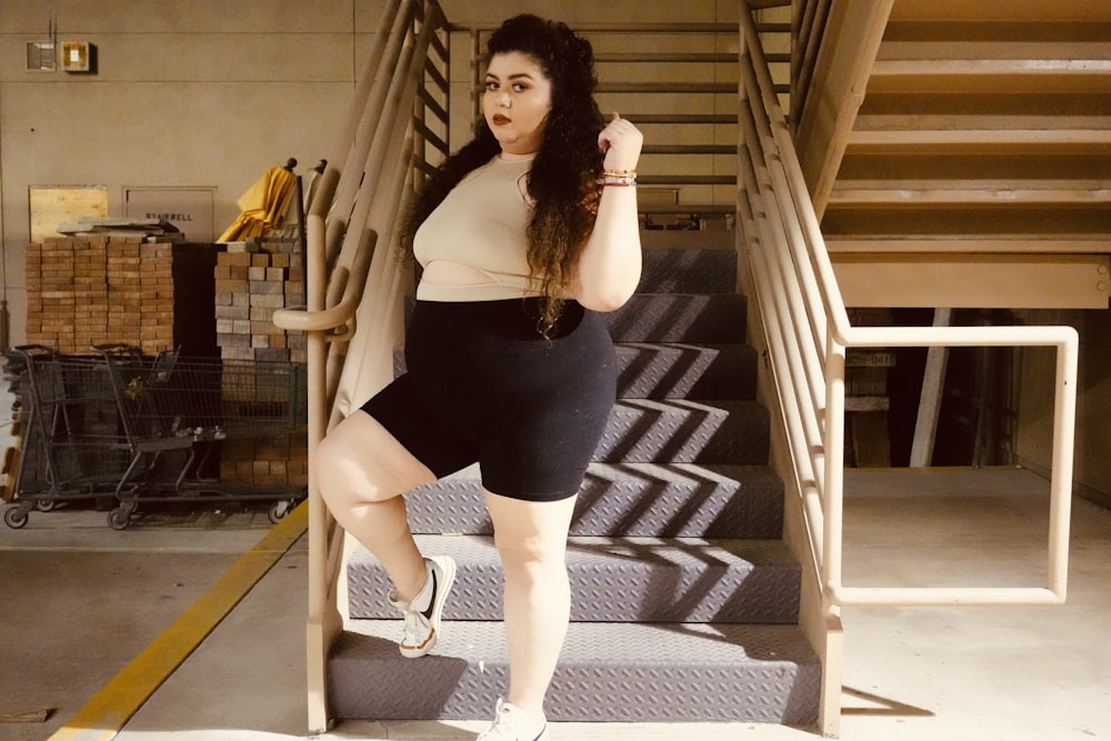 uma mulher de saia curta está de pé nas escadas