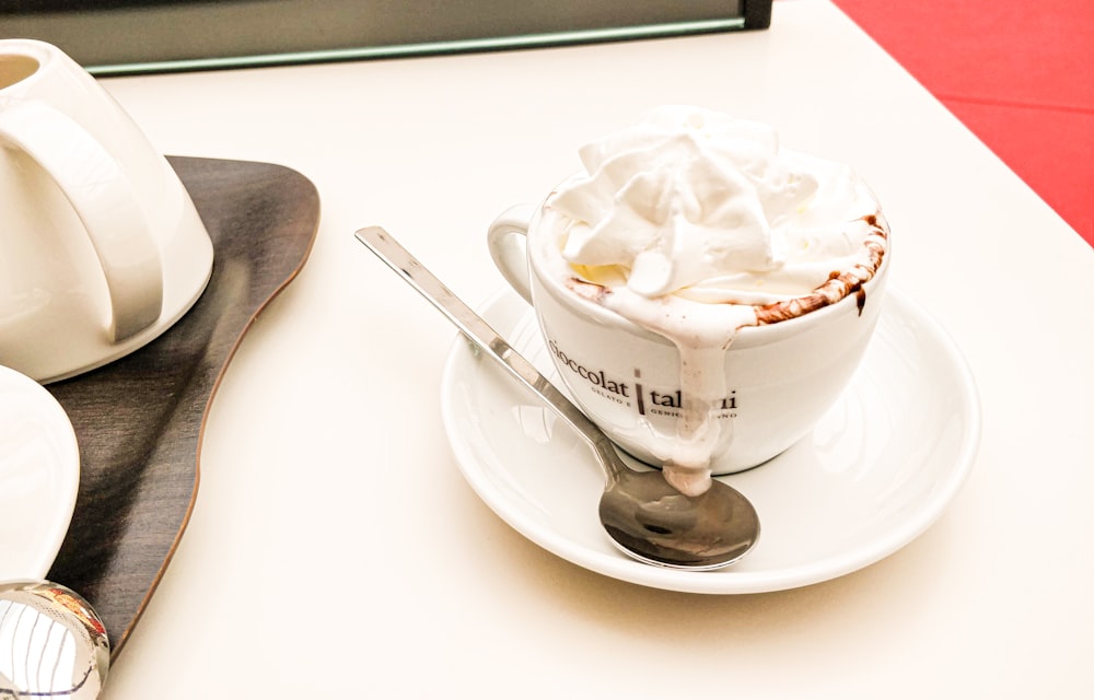 a white plate topped with a cup of hot chocolate