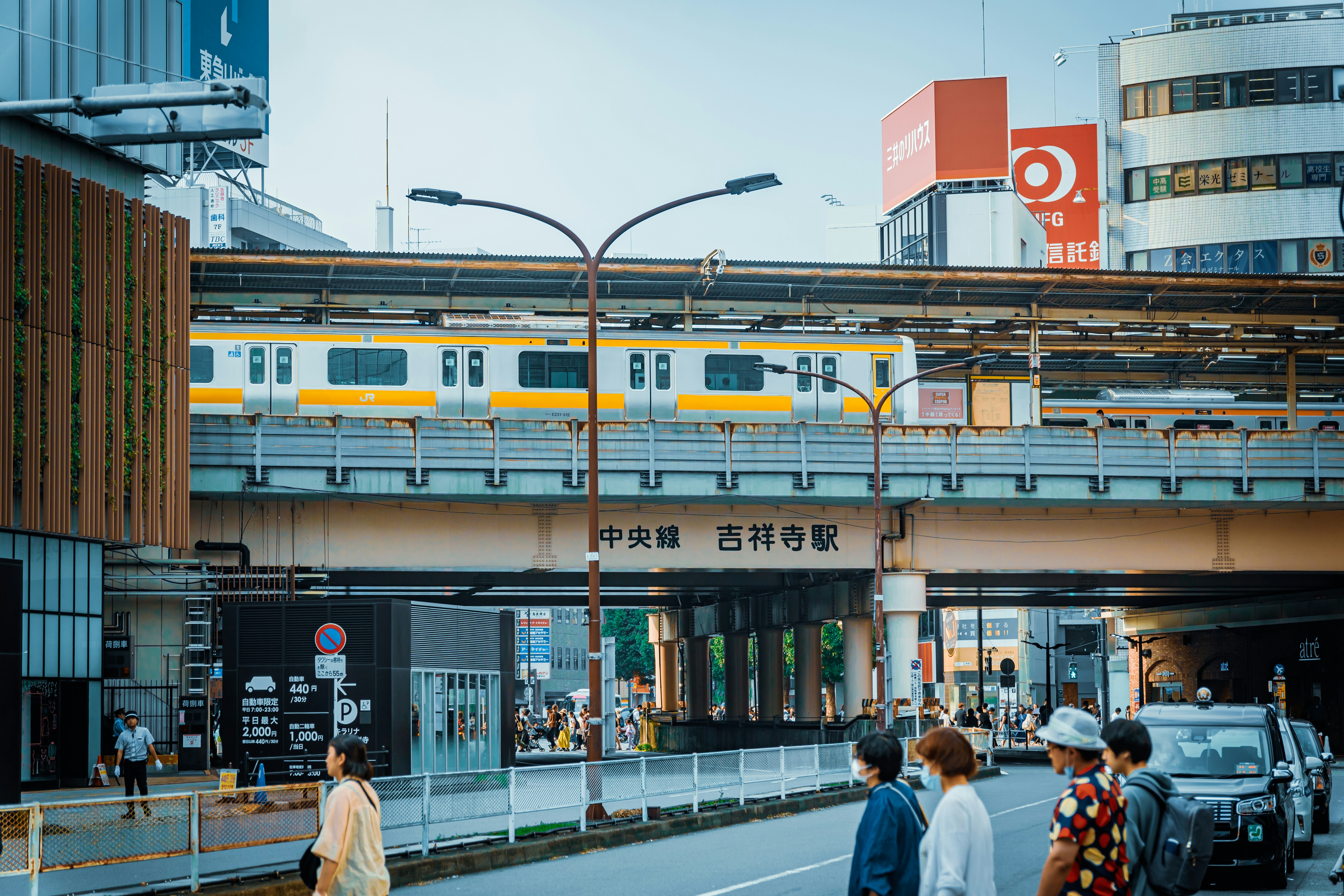 a group of people standing on a sidewalk next to a train