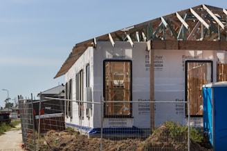 a house under construction with a fence around it