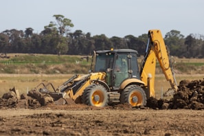 a bulldozer digging dirt in a field