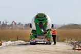 a man standing next to a green and white truck