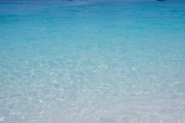 Turquoise waves gently lapping the sandy shores of Antalya beach under a bright sun