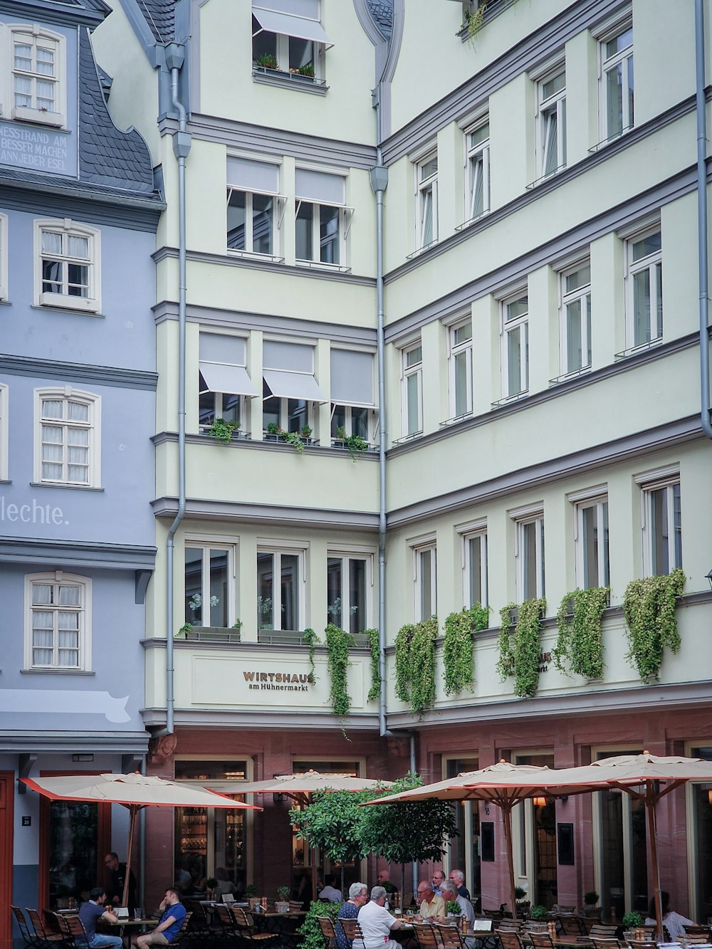 a group of people sitting at tables in front of a building