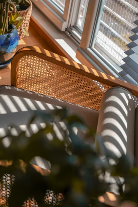 A cozy coastal wicker garden armchair nestled among blooming flowers on a sunny patio.