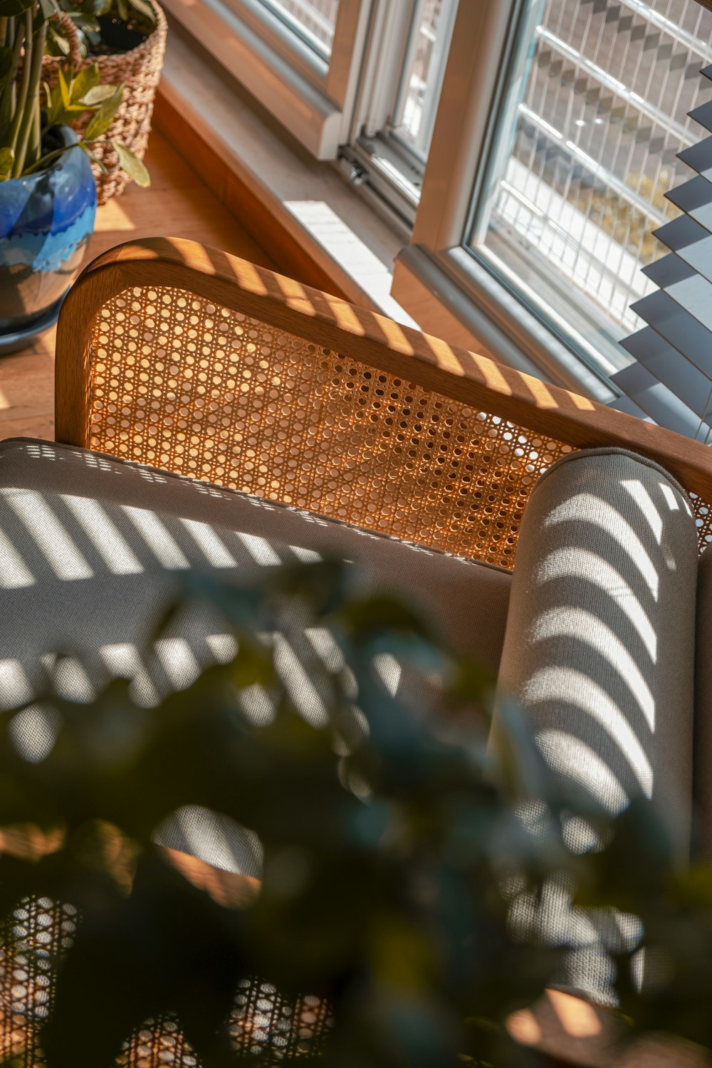 a wicker couch sitting on a wooden floor next to a window