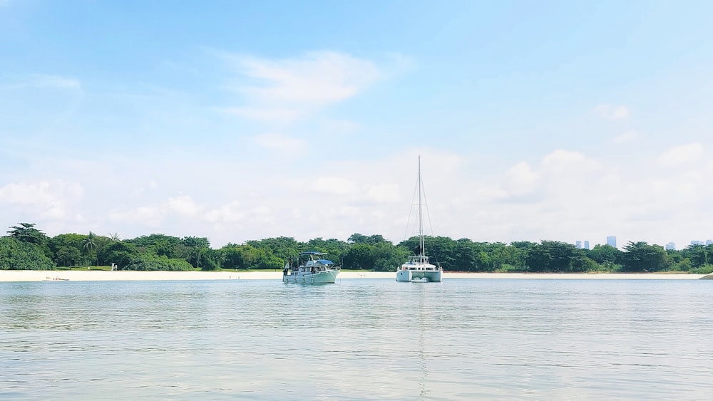 a couple of boats floating on top of a lake