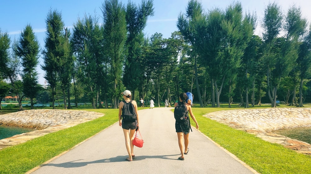 two women walking down a path in a park
