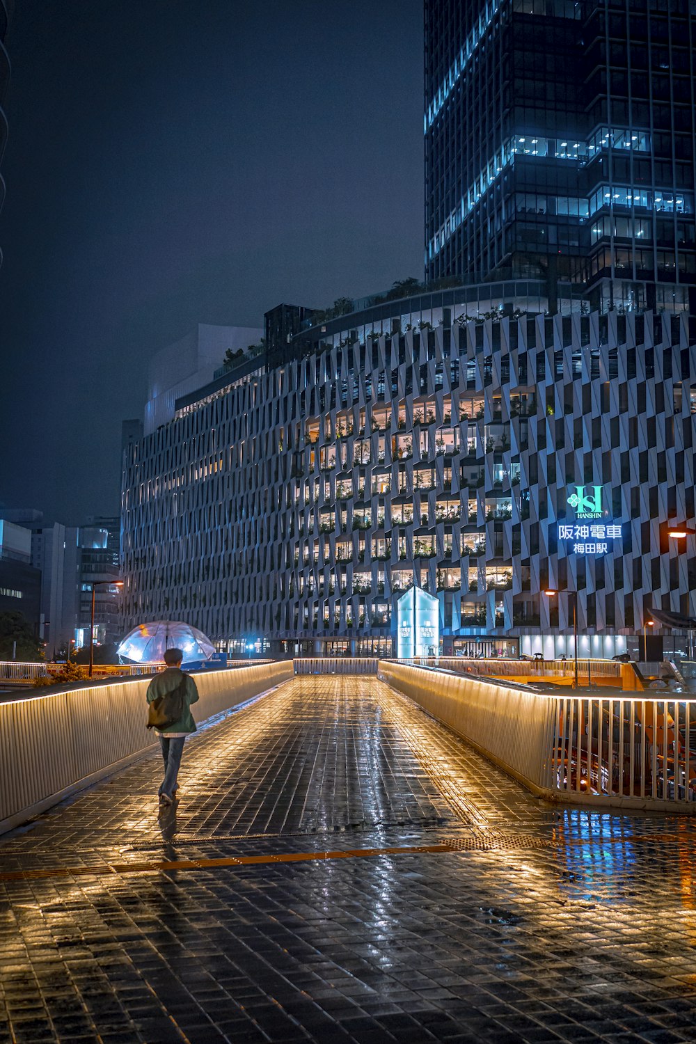 a man walking across a bridge at night