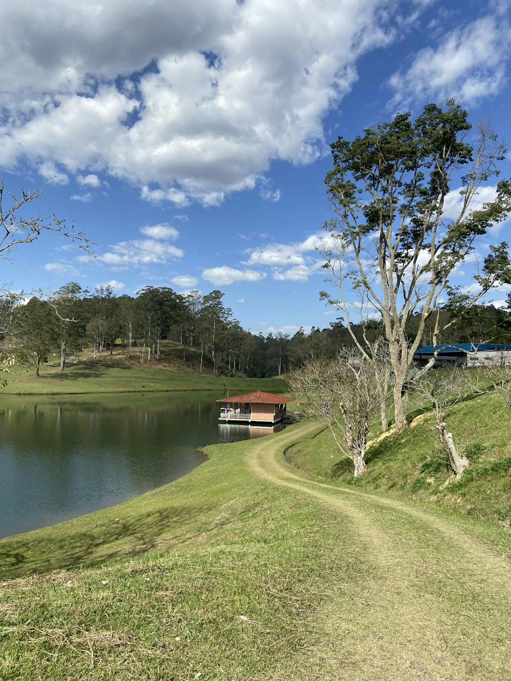 a lake with a house and a train in the distance