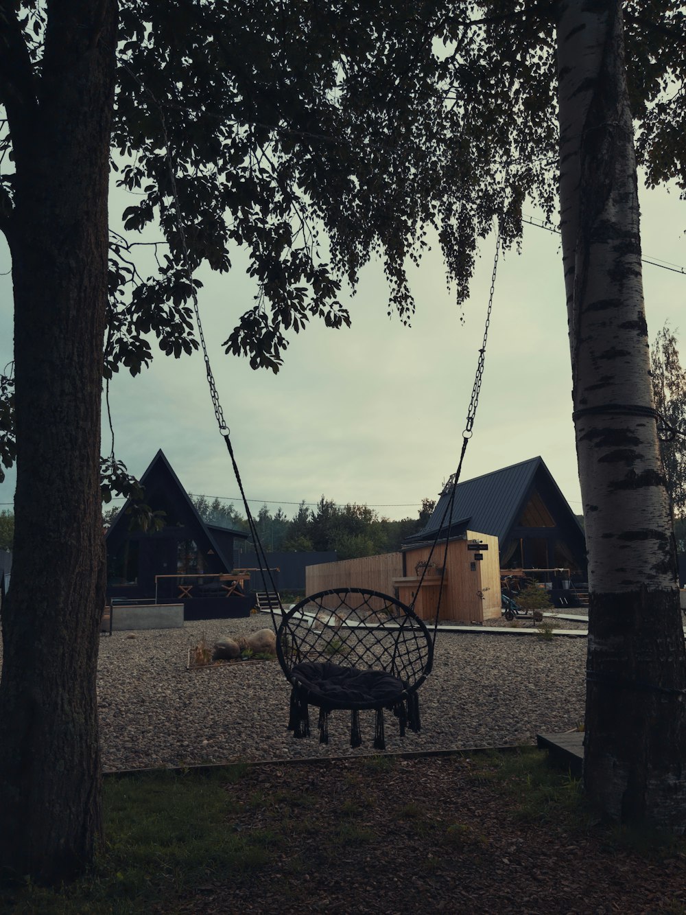 a swing chair sitting in the middle of a park