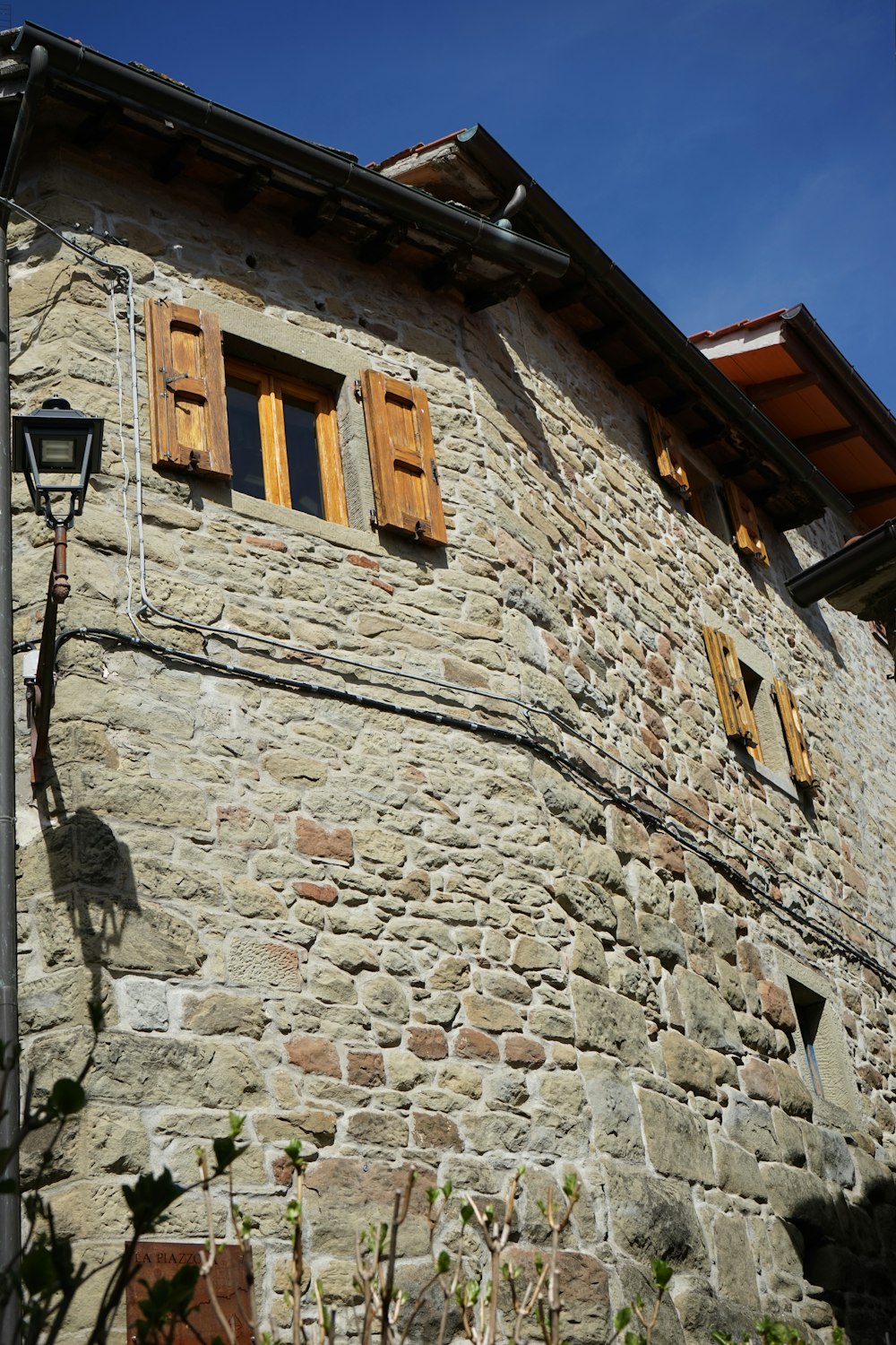a stone building with wooden shutters and windows