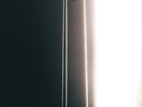 Close-up of a smooth, dark blackout curtain panel softly filtering light.