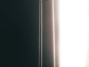 Close-up of a curtain slightly parted, hinting at a reveal.