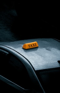 a yellow taxi sign sitting on top of a car