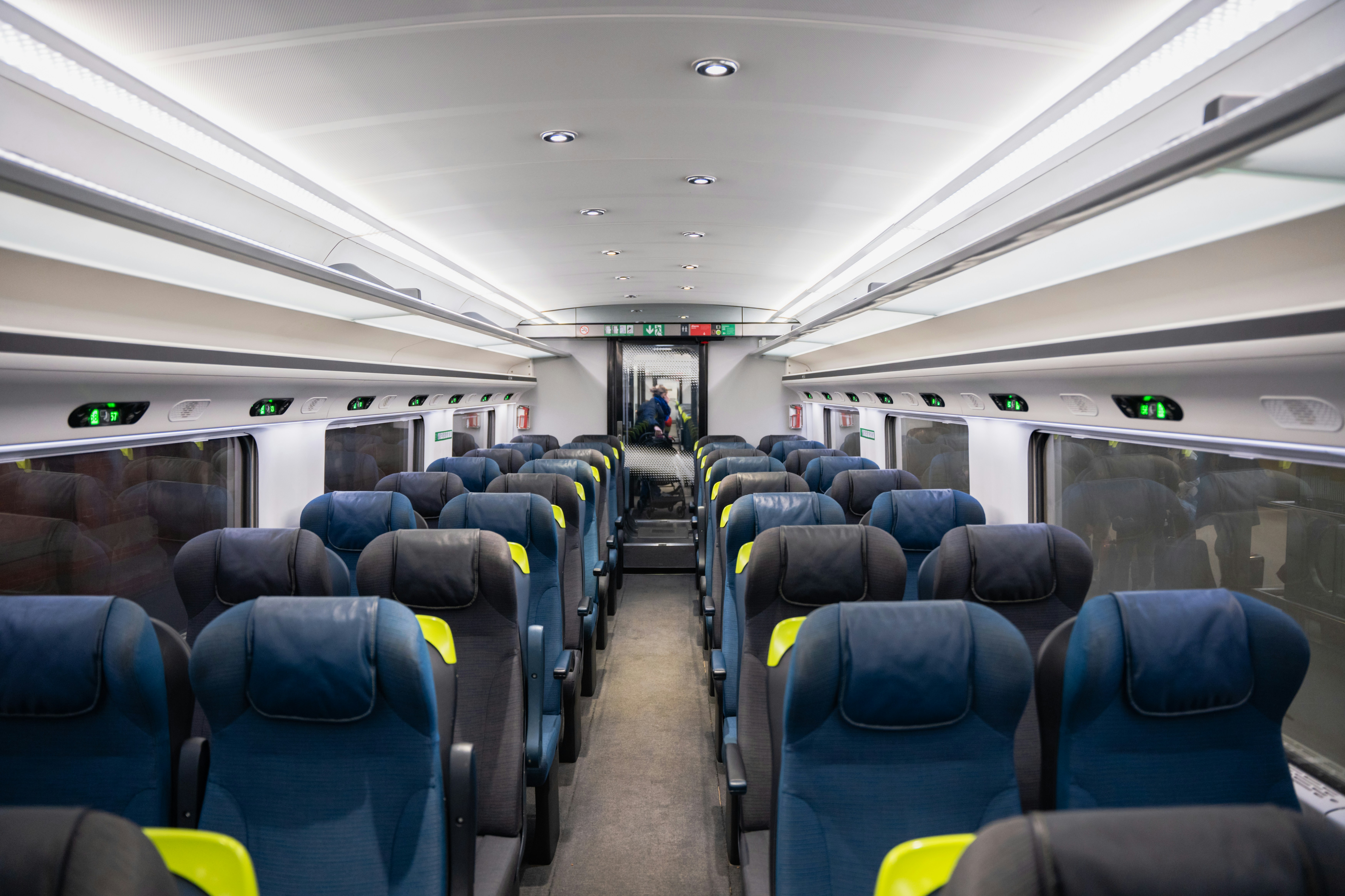 an empty train car with blue and yellow seats, 