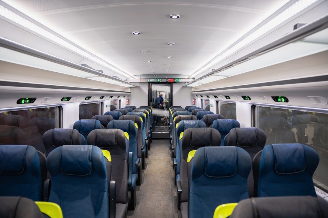 an empty train car with blue and yellow seats,