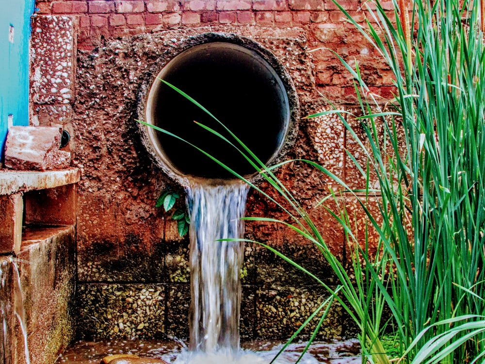 a pipe running out of a pipe on a brick wall