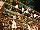 Close-up of colorful garden wind chimes gently swaying in a sunny backyard breeze.