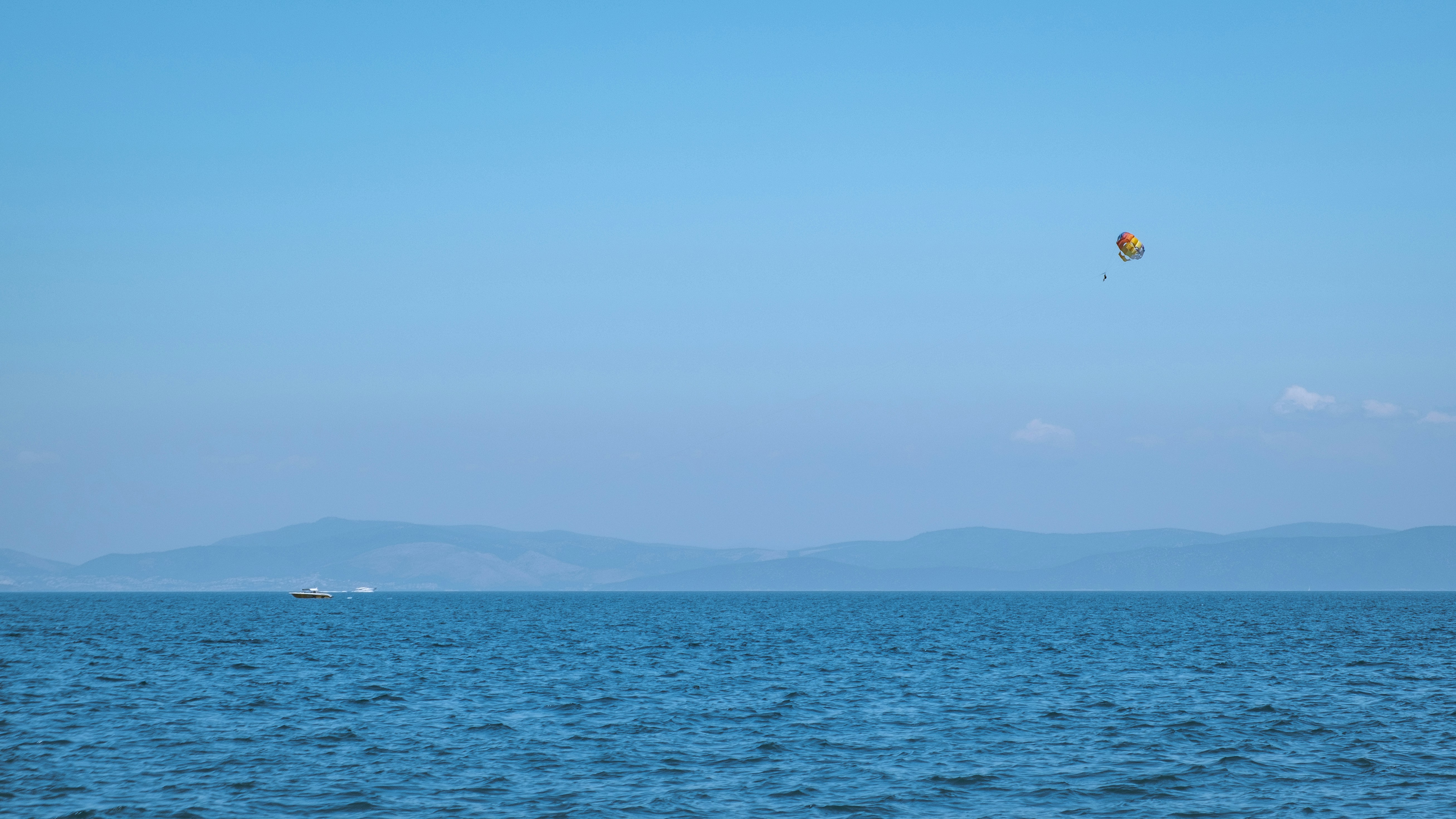 a large body of water with a kite flying over it