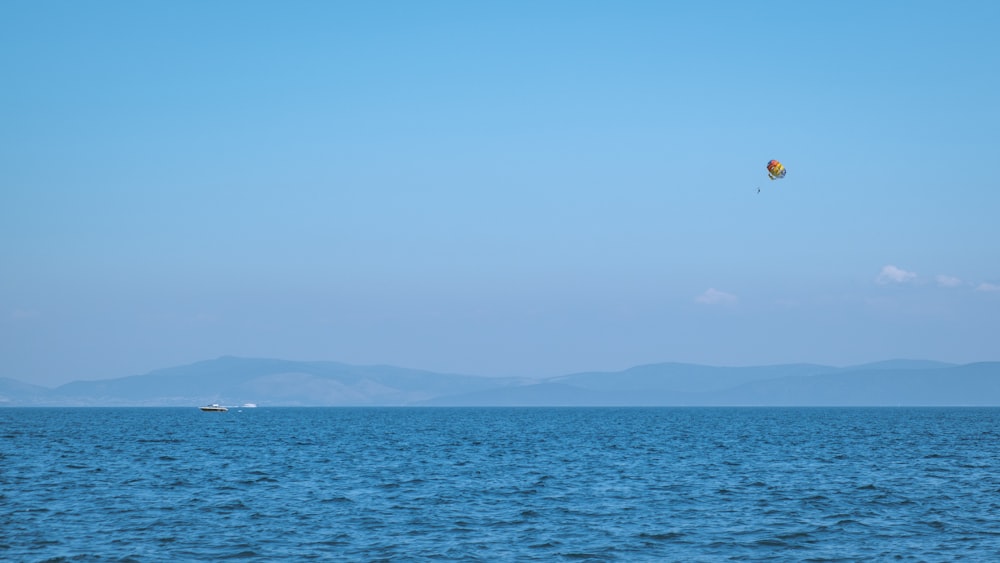 a large body of water with a kite flying over it