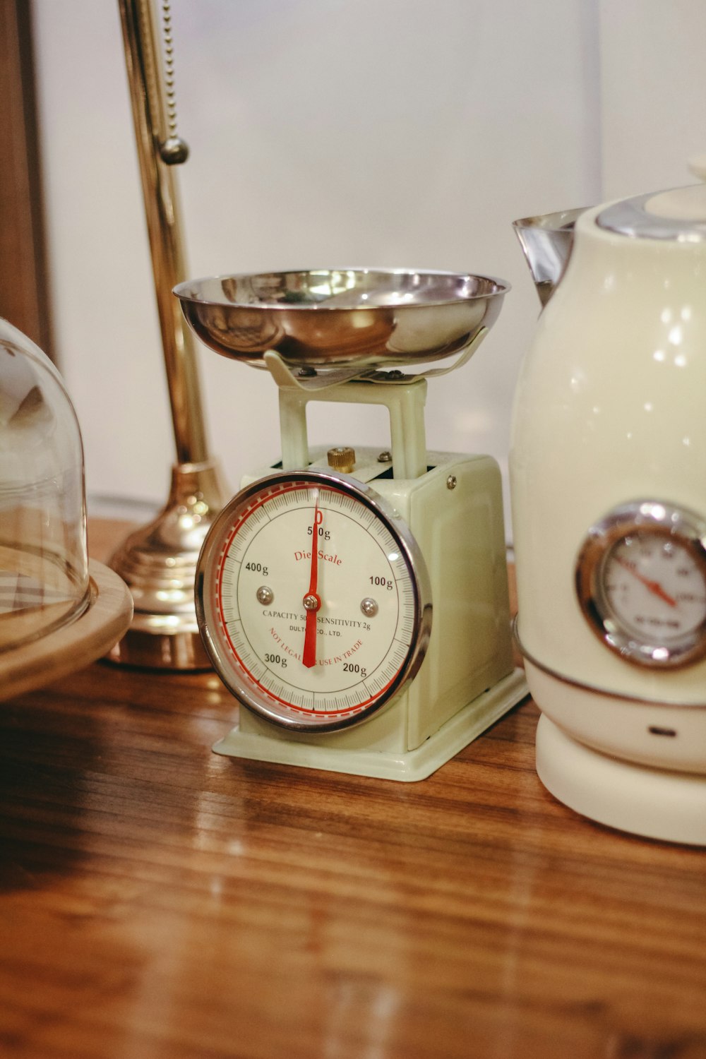 a kitchen scale and a tea kettle on a table