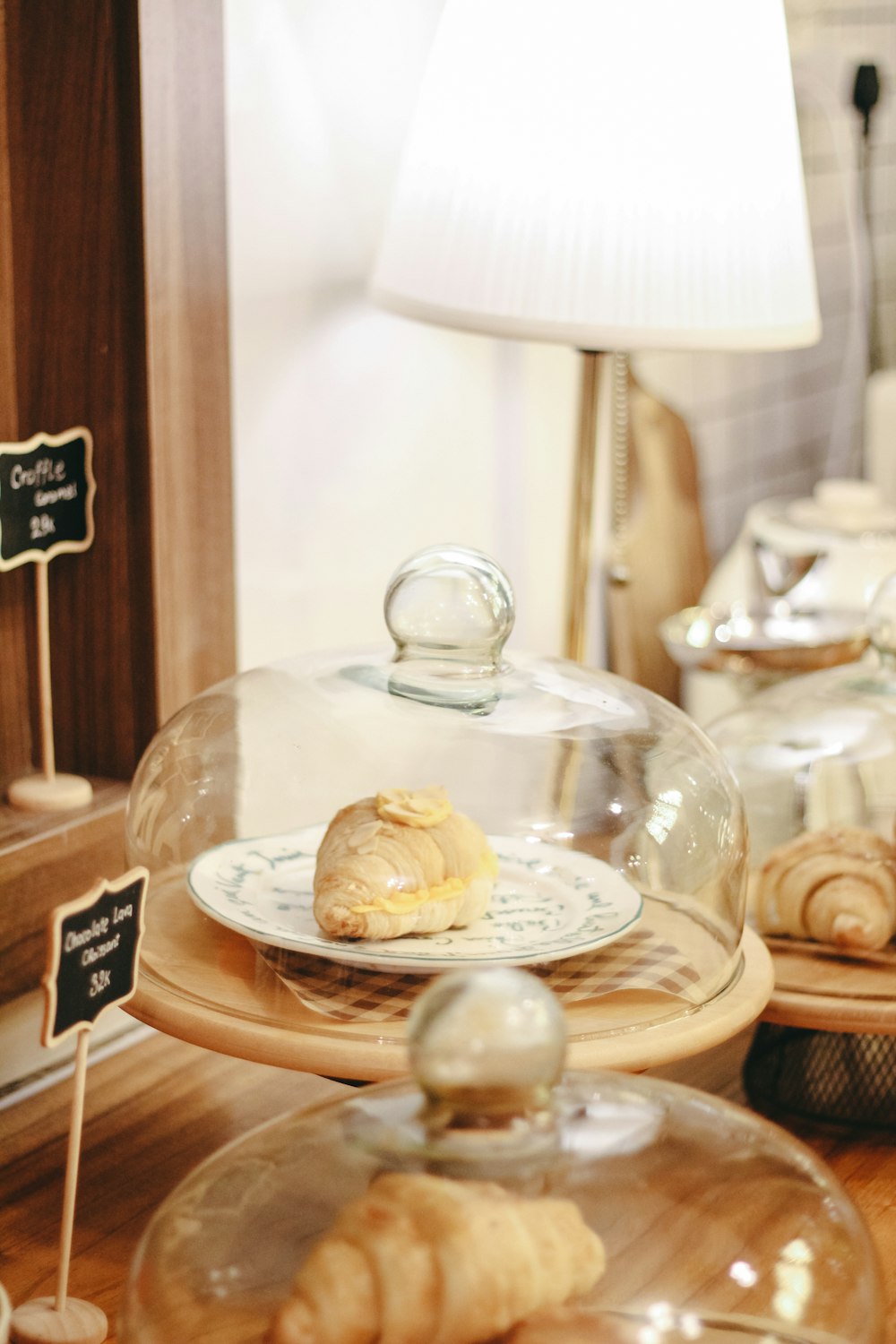 a table topped with lots of pastries under a glass dome