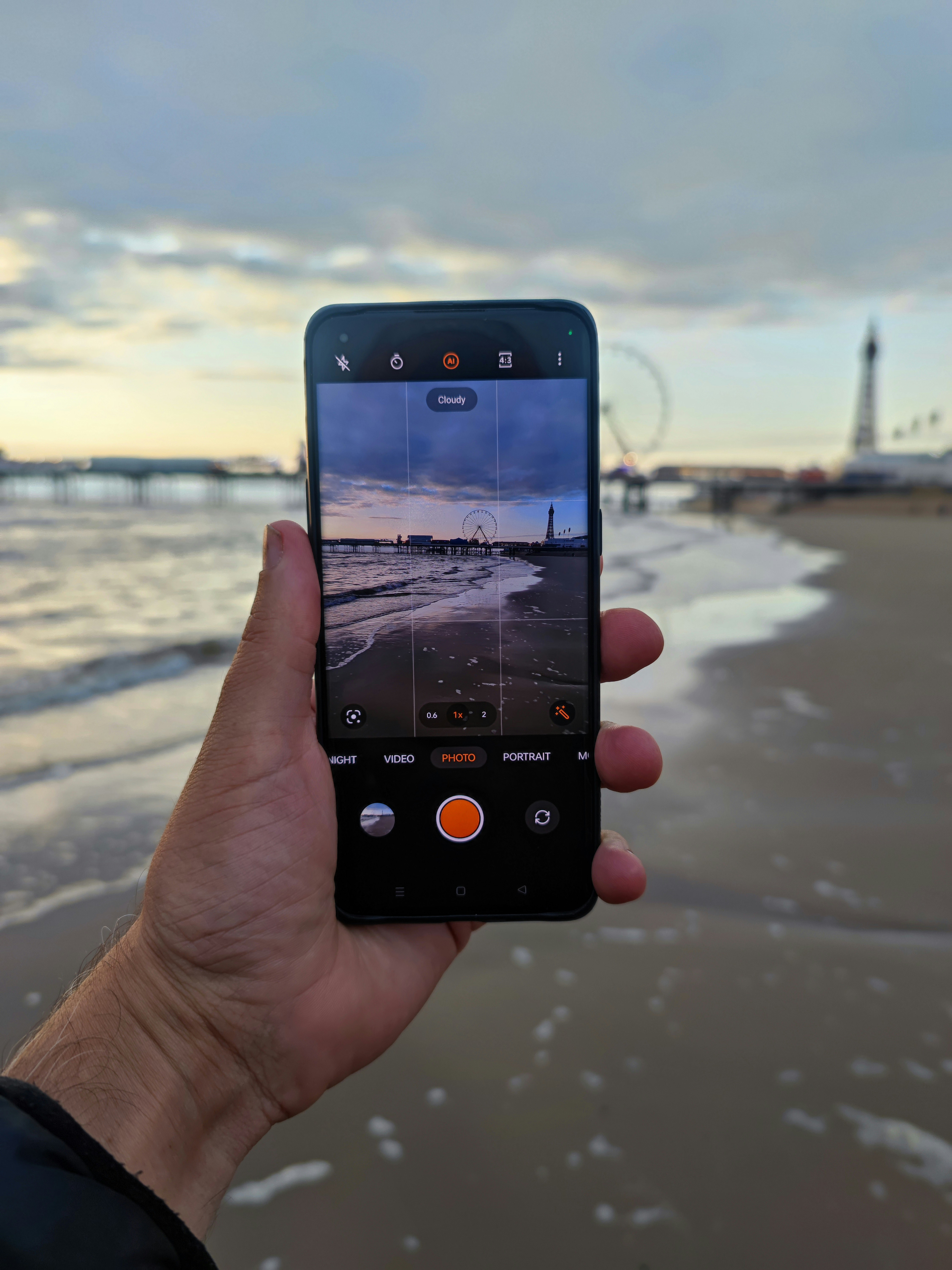 a person taking a picture of the beach with their cell phone