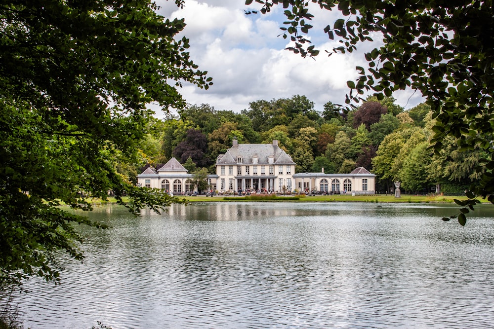 a large white house sitting on top of a lake