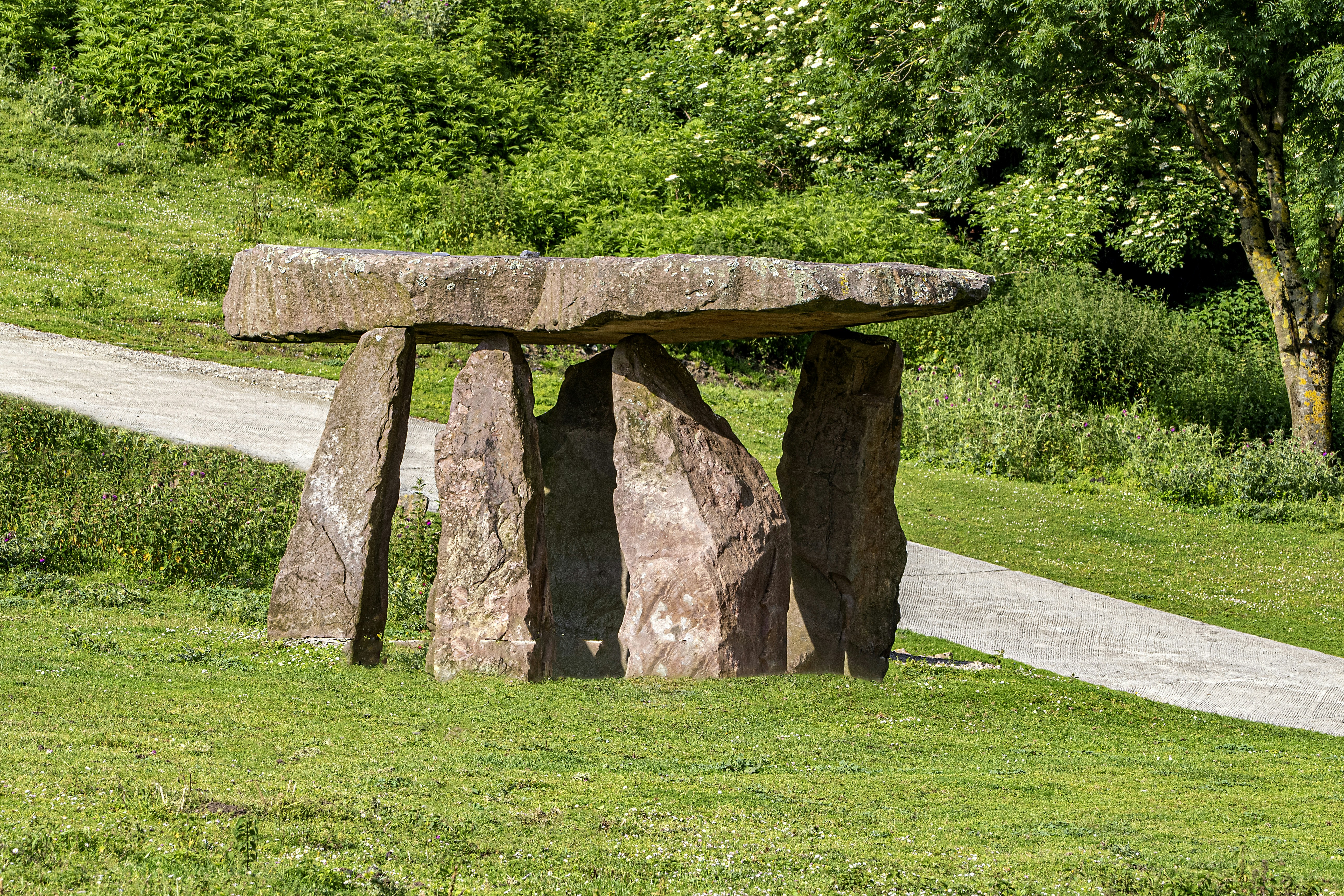 a stone bench sitting on top of a lush green field
